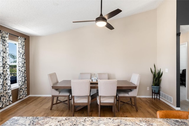 8804 Lariat Loop, Elizabeth, CO 80107 - dining area with wood finished floors, ceiling fan, lofted ceiling, and a textured ceiling