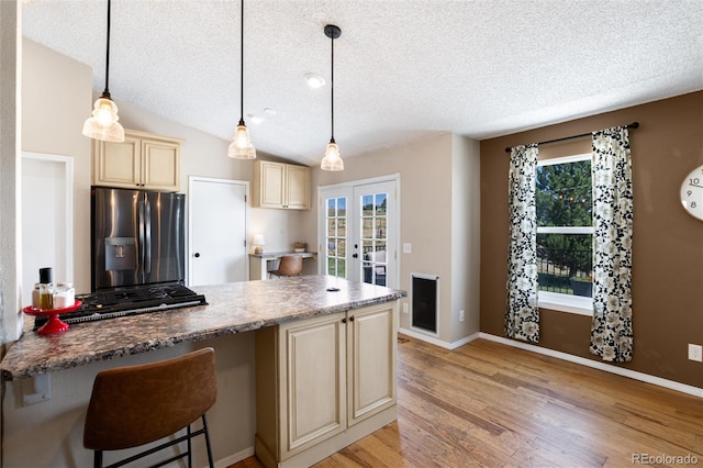8804 Lariat Loop, Elizabeth, CO 80107 - kitchen featuring stainless steel fridge, cream cabinetry, french doors, a textured ceiling, and light wood-type flooring