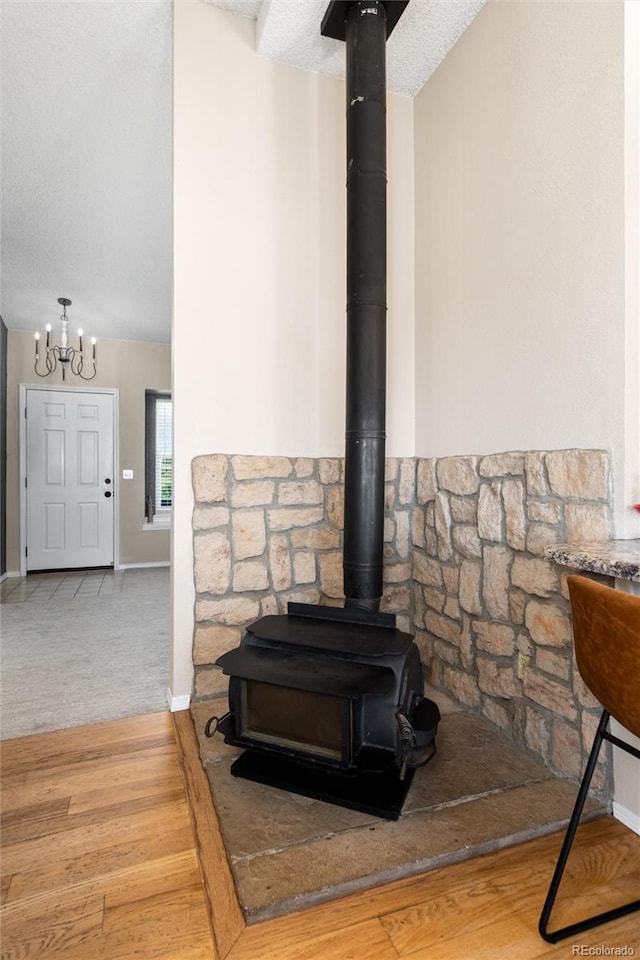 8804 Lariat Loop, Elizabeth, CO 80107 - detailed view of a wood stove, a chandelier, wood finished floors, and carpet flooring