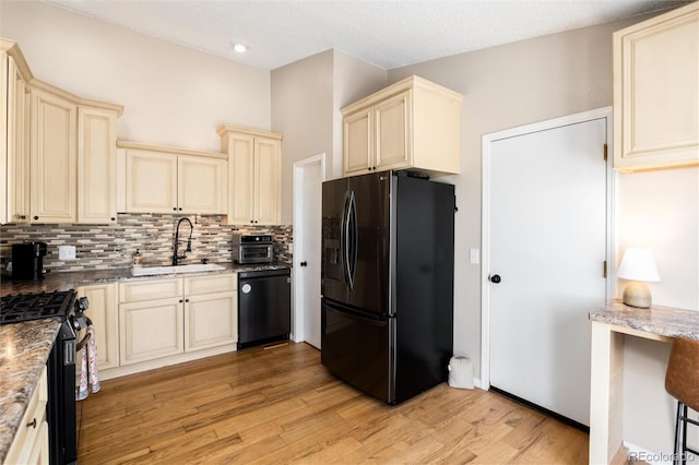 8804 Lariat Loop, Elizabeth, CO 80107 - kitchen with cream cabinets, black appliances, backsplash, light wood finished floors, and recessed lighting