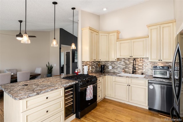 8804 Lariat Loop, Elizabeth, CO 80107 - kitchen with cream cabinetry, black appliances, a peninsula, backsplash, and lofted ceiling
