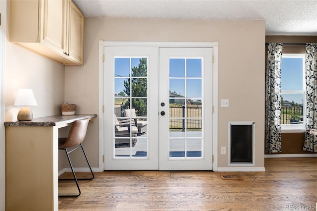 8804 Lariat Loop, Elizabeth, CO 80107 - doorway with french doors, light wood-style flooring, and a textured ceiling