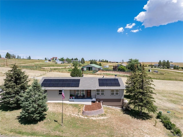 8804 Lariat Loop, Elizabeth, CO 80107 - view of front of home with roof mounted solar panels, covered porch, a rural view, and a front lawn
