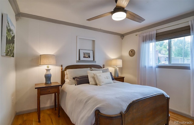 bedroom with ornamental molding, wood finished floors, baseboards, and ceiling fan