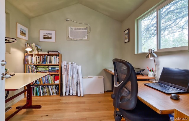office with wood finished floors, an AC wall unit, and vaulted ceiling