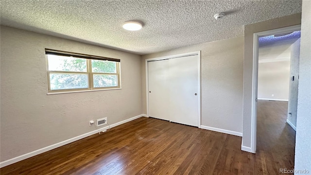 11718 Keough Dr, Northglenn, CO 80233 - unfurnished bedroom featuring a textured ceiling, wood finished floors, a closet, and a textured wall