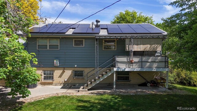 11718 Keough Dr, Northglenn, CO 80233 - rear view of property with a patio area, roof mounted solar panels, stairway, and a lawn