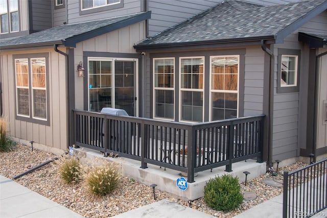 view of side of home featuring a porch and a shingled roof