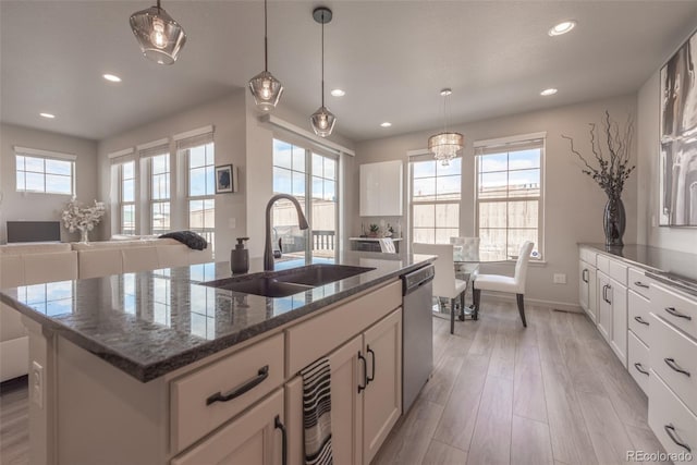 kitchen featuring a sink, light wood-style floors, dishwasher, and a healthy amount of sunlight