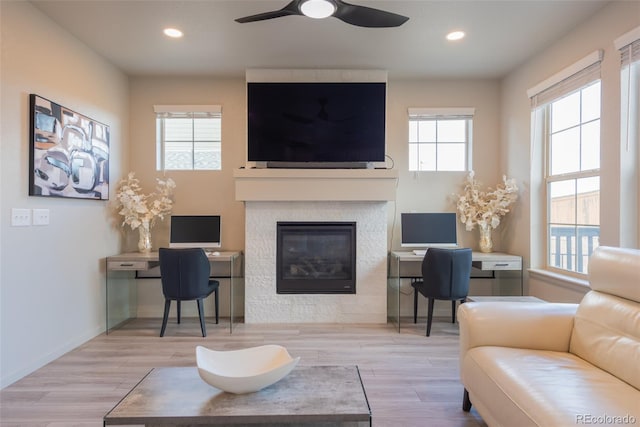 living room with a ceiling fan, wood finished floors, recessed lighting, a large fireplace, and baseboards