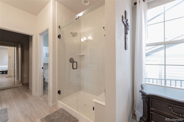 ensuite bathroom featuring plenty of natural light, toilet, and a shower stall