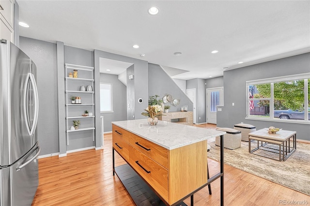 1903 W 66th Ave, Denver, CO 80221 - kitchen with freestanding refrigerator, light wood-style floors, a breakfast bar area, a center island, and plenty of natural light
