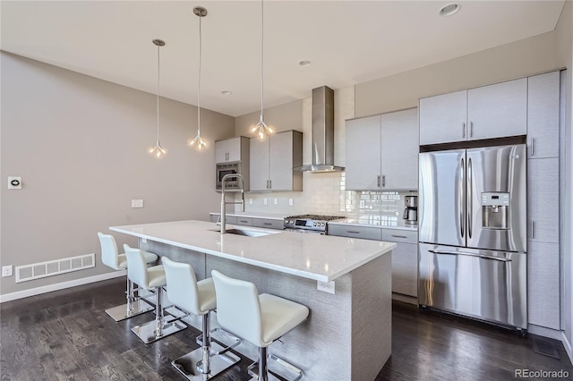 28424 Tepees Way, Evergreen, CO 80439 - kitchen with appliances with stainless steel finishes, wall chimney range hood, dark wood-style floors, tasteful backsplash, and a breakfast bar