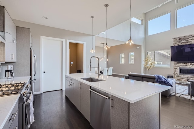 28424 Tepees Way, Evergreen, CO 80439 - kitchen with stainless steel appliances, open floor plan, dark wood-style flooring, modern cabinets, and a kitchen island with sink