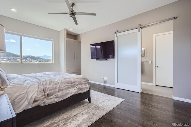 28424 Tepees Way, Evergreen, CO 80439 - bedroom featuring dark wood finished floors, recessed lighting, a barn door, and a ceiling fan