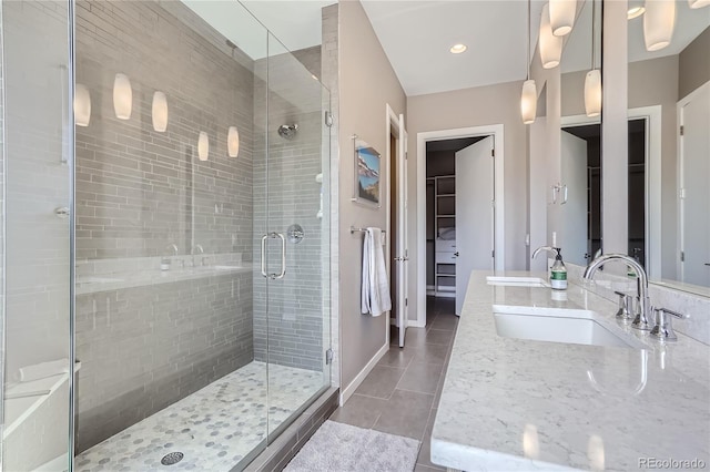 28424 Tepees Way, Evergreen, CO 80439 - full bathroom featuring tile patterned flooring, a shower stall, double vanity, and a walk in closet