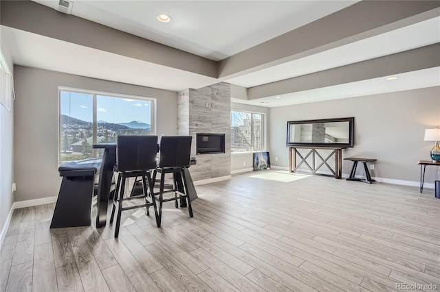 28424 Tepees Way, Evergreen, CO 80439 - dining room with light wood finished floors, a fireplace, a mountain view, and recessed lighting