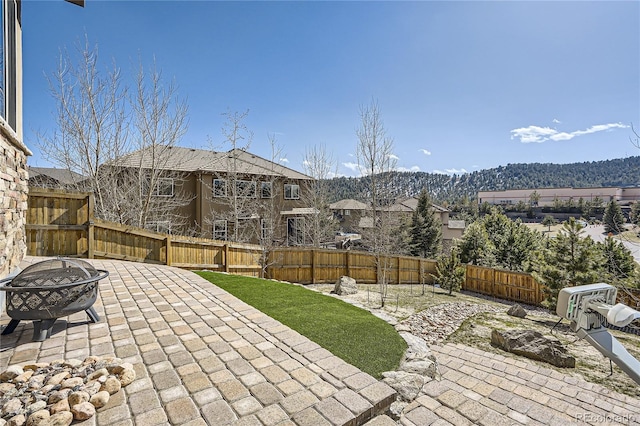 28424 Tepees Way, Evergreen, CO 80439 - fenced backyard with an outdoor fire pit, a patio, and a mountain view