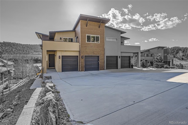 28424 Tepees Way, Evergreen, CO 80439 - view of front of house with an attached garage, concrete driveway, and stucco siding