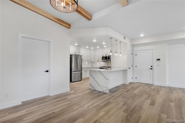 kitchen featuring light wood-style flooring, stainless steel appliances, a peninsula, white cabinets, and decorative backsplash