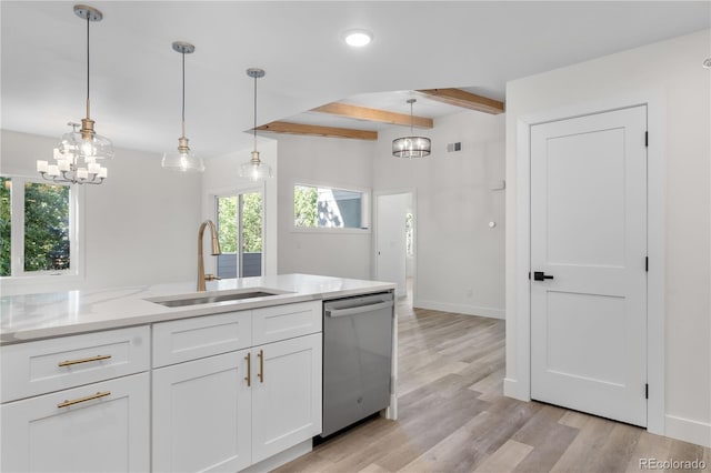 kitchen featuring light wood finished floors, white cabinets, decorative light fixtures, stainless steel dishwasher, and a sink