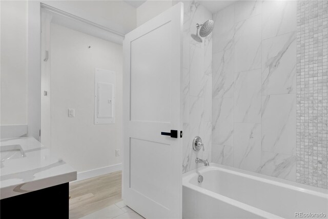 bathroom featuring double vanity, baseboards, and shower / bathing tub combination