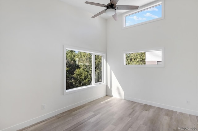 spare room featuring a ceiling fan, baseboards, and wood finished floors