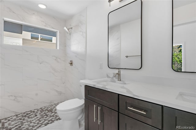 bathroom featuring toilet, marble finish floor, a wealth of natural light, and a sink