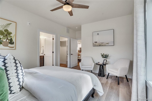 bedroom with ceiling fan, connected bathroom, visible vents, light wood-style floors, and a walk in closet