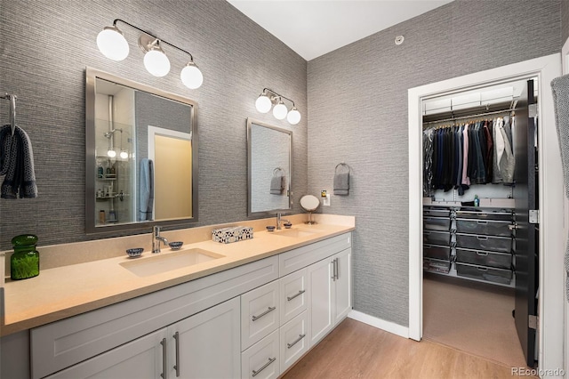 4150 Longview Ln, Boulder, CO 80301 - bathroom with double vanity, wood finished floors, a spacious closet, baseboards, and a shower