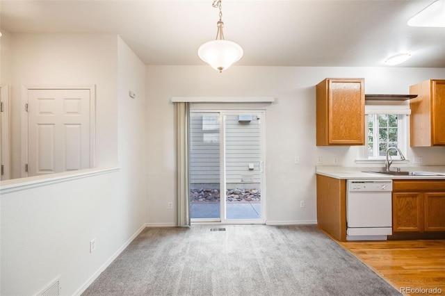 kitchen with white dishwasher, light hardwood / wood-style floors, hanging light fixtures, and sink