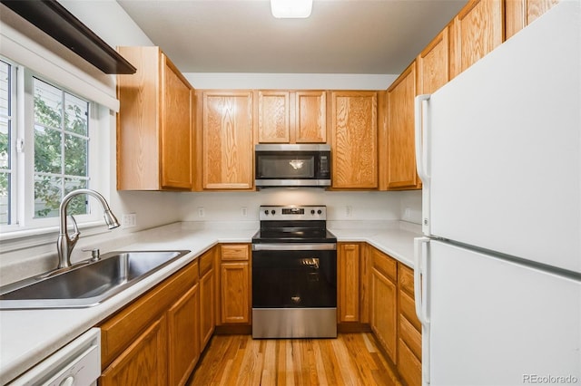 kitchen with stainless steel appliances, light hardwood / wood-style floors, and sink