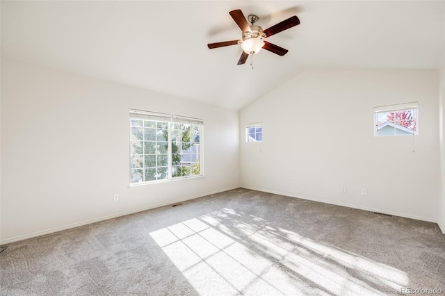 carpeted spare room featuring a wealth of natural light, lofted ceiling, and ceiling fan