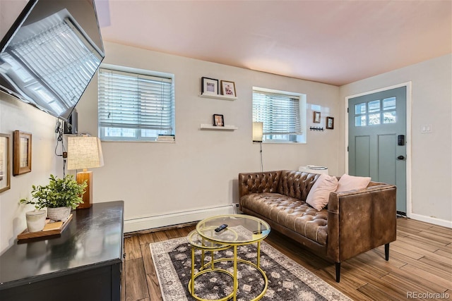 living room with plenty of natural light, hardwood / wood-style floors, and a baseboard heating unit