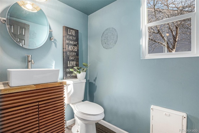 bathroom featuring vanity, toilet, and baseboards