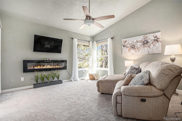 carpeted living area with baseboards, ceiling fan, vaulted ceiling, a textured ceiling, and a glass covered fireplace