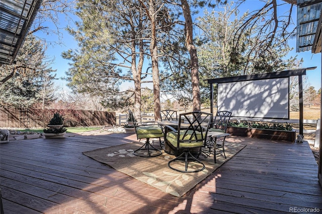 wooden terrace featuring outdoor dining space and fence