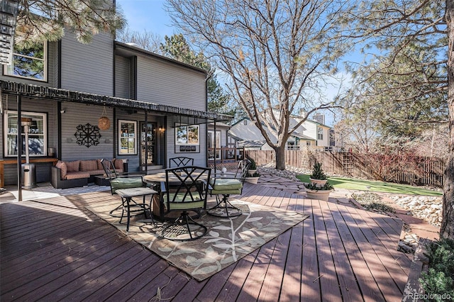 wooden terrace featuring an outdoor living space with a fire pit and fence