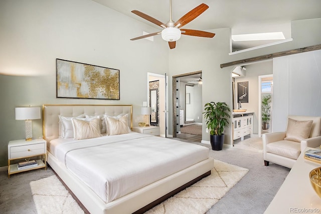 bedroom with carpet flooring, high vaulted ceiling, ensuite bathroom, and ceiling fan