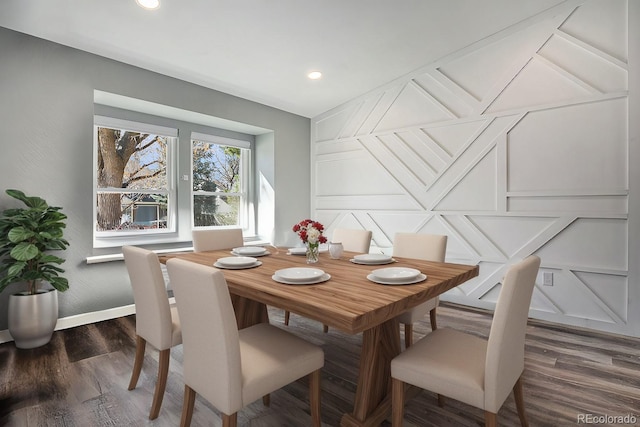 dining room featuring recessed lighting, baseboards, dark wood finished floors, and a decorative wall