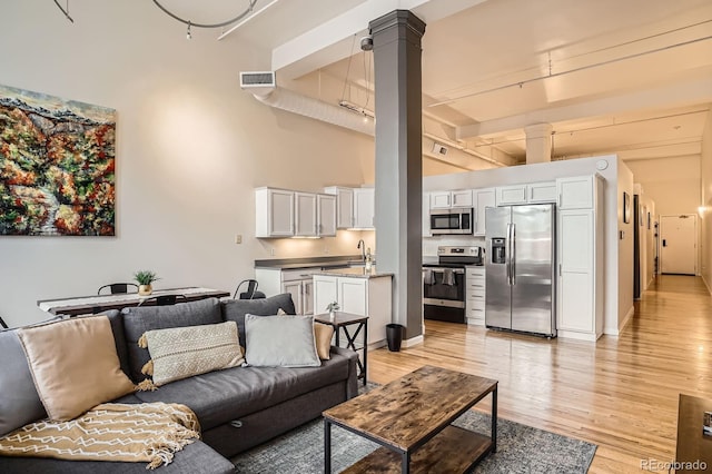 1555 California St Unit 304, Denver, CO 80202 - living area with light wood-style floors, ornate columns, and a high ceiling