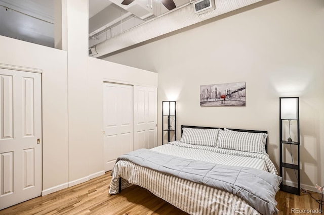 1555 California St Unit 304, Denver, CO 80202 - bedroom featuring a closet, wood finished floors, baseboards, and a towering ceiling