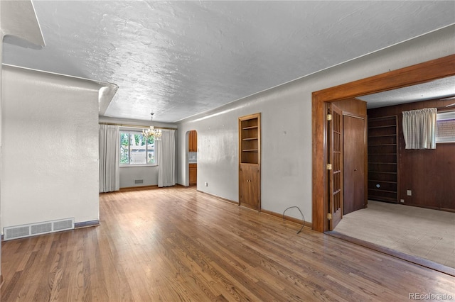 4815 S Pennsylvania St, Englewood, CO 80113 - unfurnished living room with a chandelier, wood finished floors, and a textured ceiling
