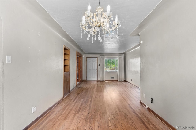 4815 S Pennsylvania St, Englewood, CO 80113 - unfurnished living room featuring a chandelier, wood finished floors, and built in features