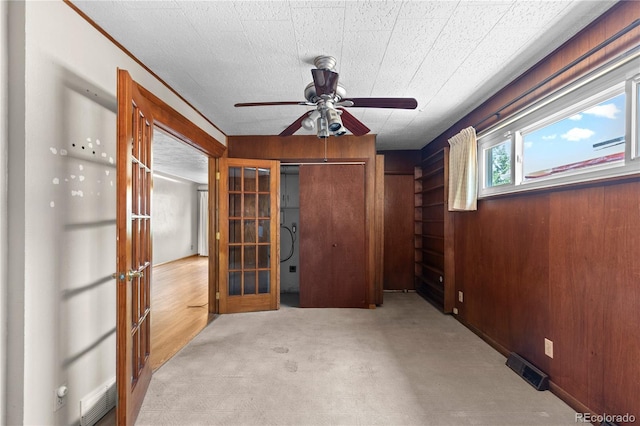 4815 S Pennsylvania St, Englewood, CO 80113 - unfurnished bedroom with french doors, carpet flooring, wood walls, and ceiling fan