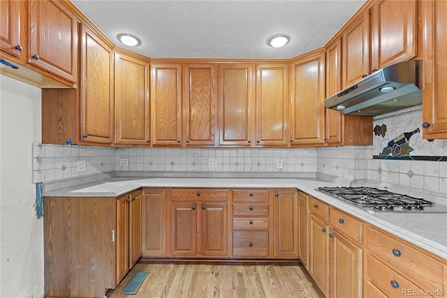4815 S Pennsylvania St, Englewood, CO 80113 - kitchen with under cabinet range hood, stainless steel gas cooktop, light countertops, and decorative backsplash