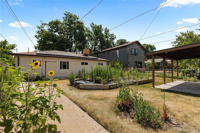 4815 S Pennsylvania St, Englewood, CO 80113 - rear view of house featuring a vegetable garden, roof mounted solar panels, and a patio area