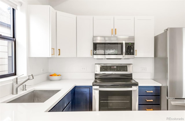 3069 Tejon St Unit B, Denver, CO 80211 - kitchen featuring stainless steel appliances, blue cabinets, and white cabinetry