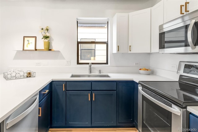 3069 Tejon St Unit B, Denver, CO 80211 - kitchen featuring stainless steel appliances, blue cabinetry, white cabinetry, and light countertops
