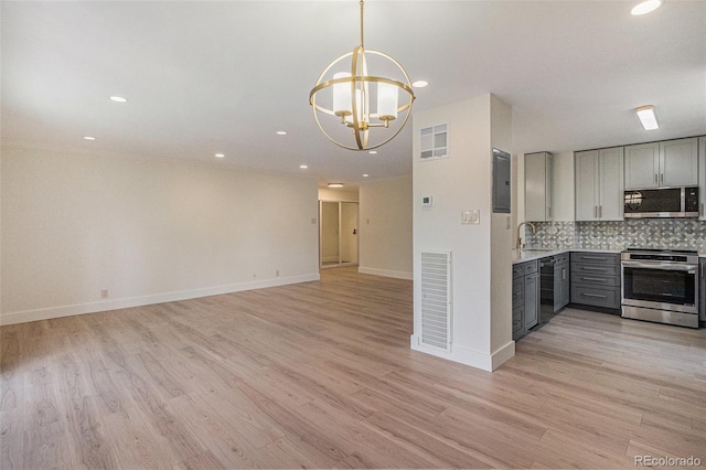 460 S Marion Pkwy Unit 604, Denver, CO 80209 - kitchen with appliances with stainless steel finishes, gray cabinetry, light countertops, a chandelier, and light wood finished floors